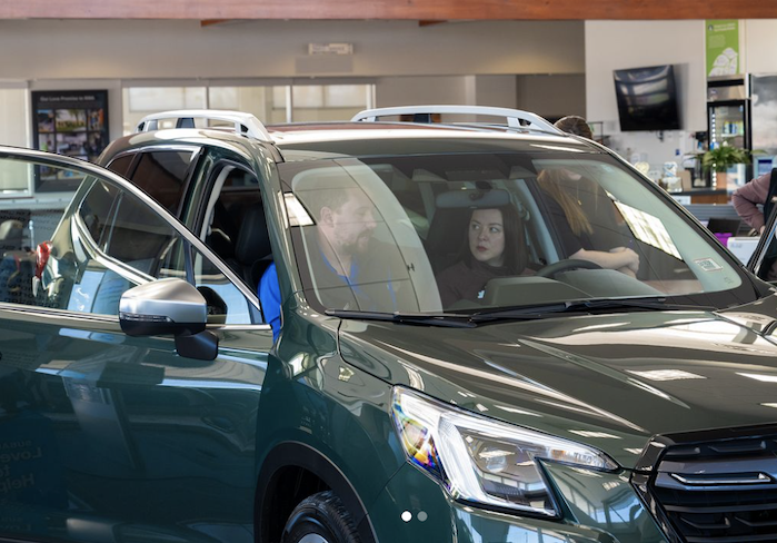 2024 Subaru Outback in the showroom with a customer
