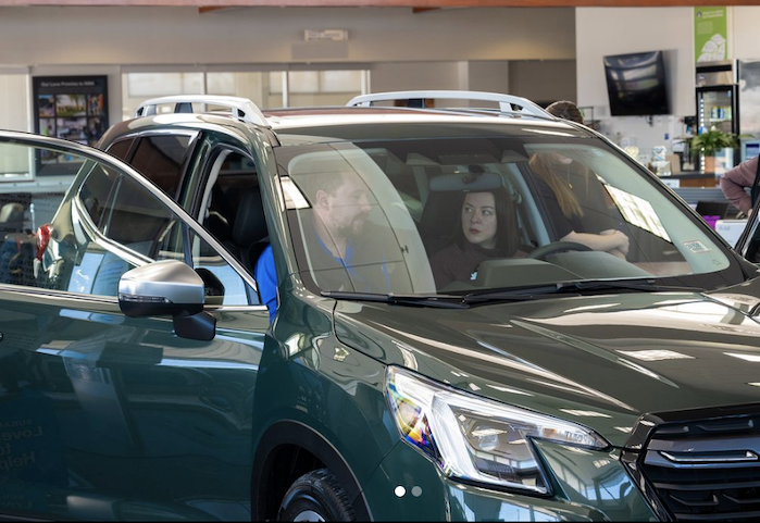 customer looking at a new 2024 Subaru Outback in the showroom