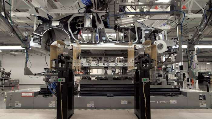 Image showing a battery pack being installed into a Lucid Air body shell from beneath.