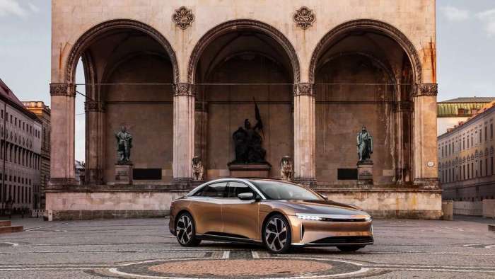 A Lucid Air Dream Edition is pictured parked outside a historic building in Munich wearing its trademark Eureka Gold paint.