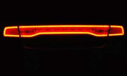 The taillight of the 2012 Dodge Charger SRT8 lit up at night.