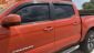 Orange color new Toyota Tacoma with tinted windows