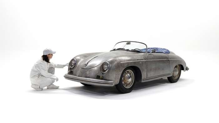 Image showing a person in white overalls crouching beside the Porsche 356 Bonsai art car.