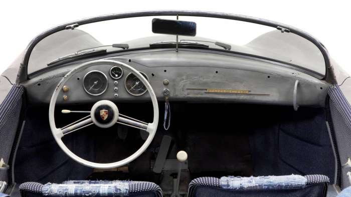 Interior of the Porsche 356 Bonsai art car showing its rough unpainted metal dash and patchwork seat covers.