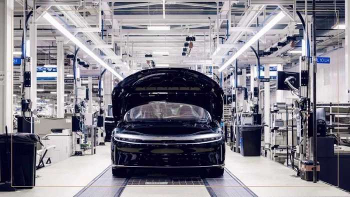 A black Lucid Air is pictured on the assembly line with its hood raised.