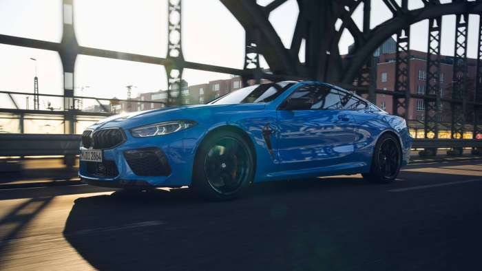 Rolling shot of a blue BMW M8 Competition coupe.