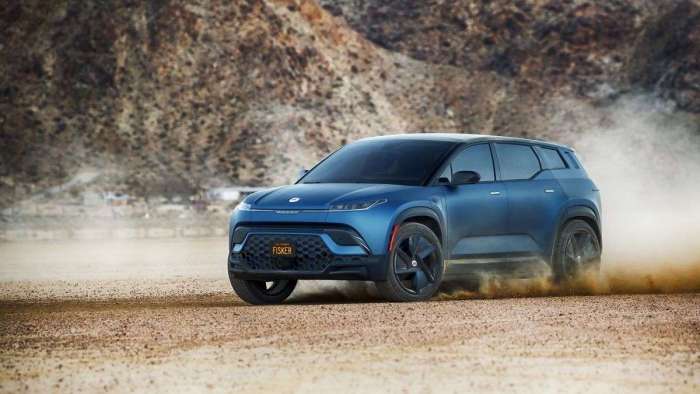 A Fisker Ocean SUV is pictured drifting on a dry lake bed with a plume of dust behind it.