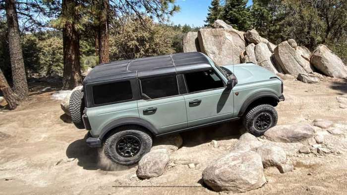 Image shows a gray four-door Ford Bronco off-roading in rocky terrain