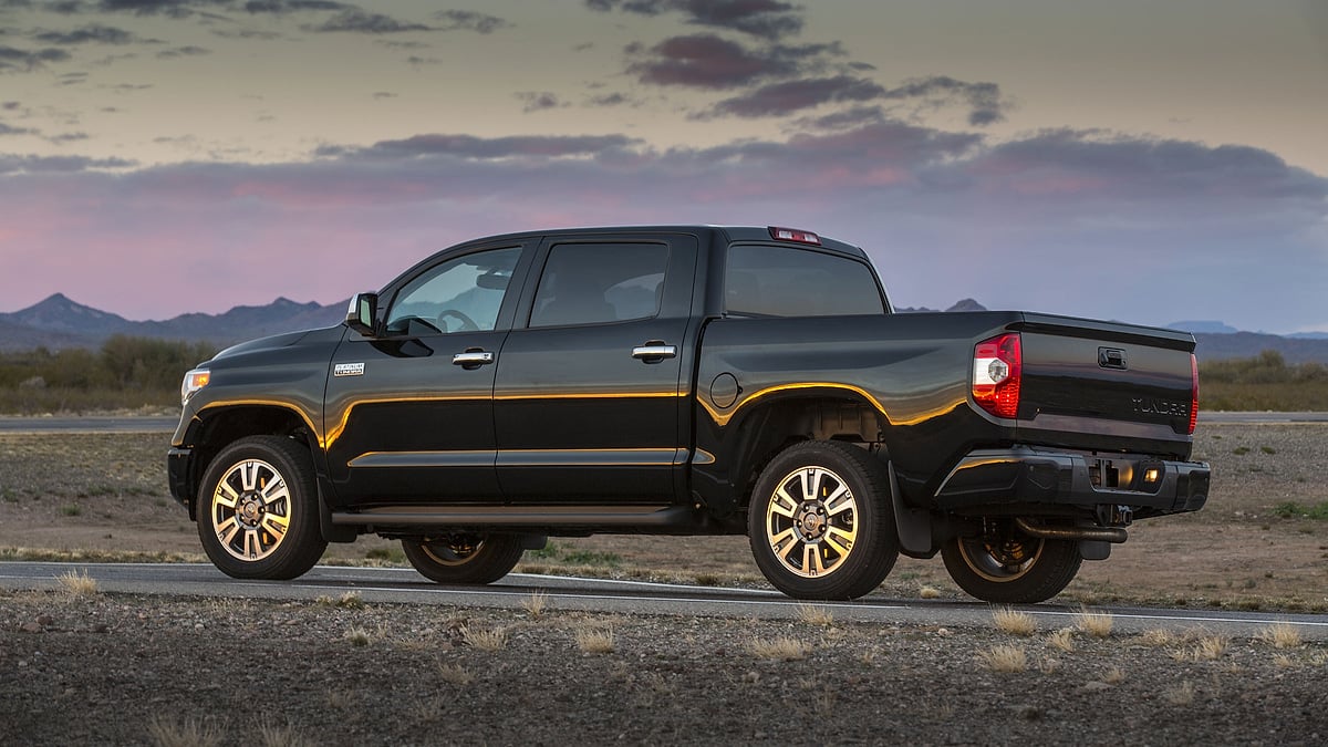 Black 2014 Toyota Tundra Platinum shown from the rear side in a desert landscape at sunset.
