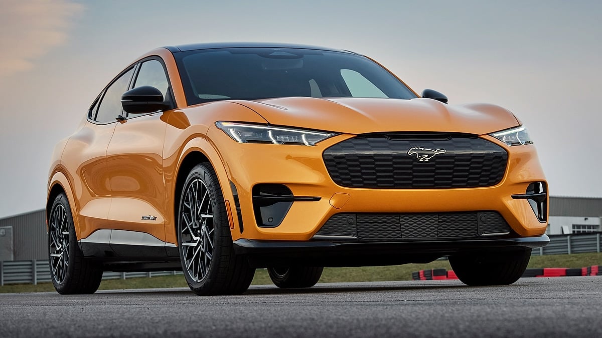 Orange 2021 Ford Mustang Mach-E GT shown from a low front three-quarter angle on a track.