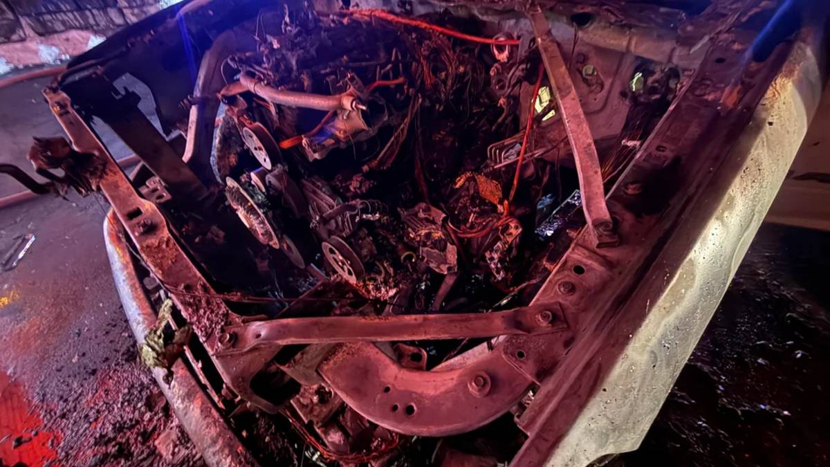 The burnt and melted engine bay of a Ram truck after a fire.