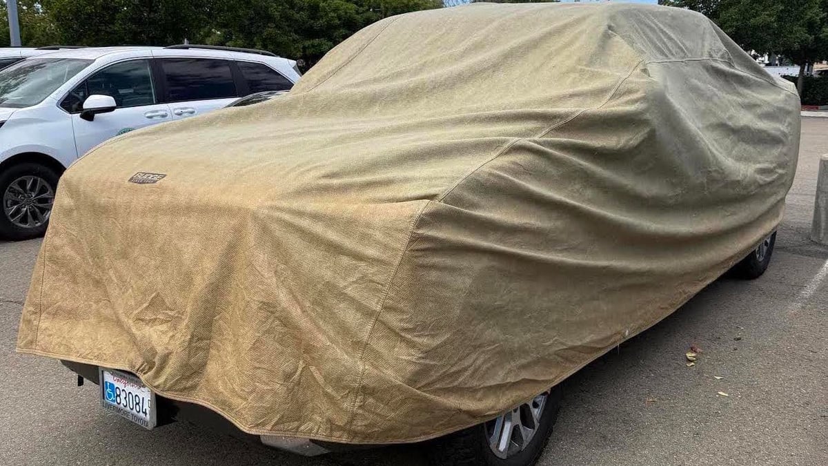 2023 Toyota Tundra with a car cover stranded on the Toyota dealer's service lot waiting for a new recall engine