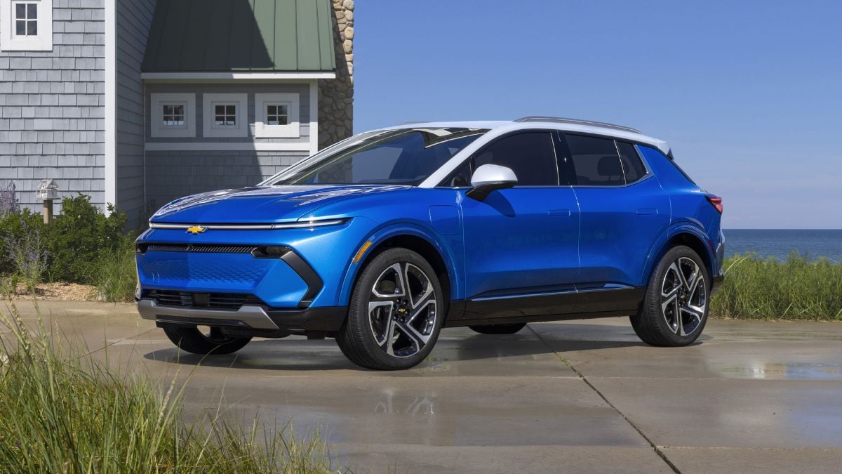 Bright blue Chevrolet electric SUV parked outside coastal house with ocean view