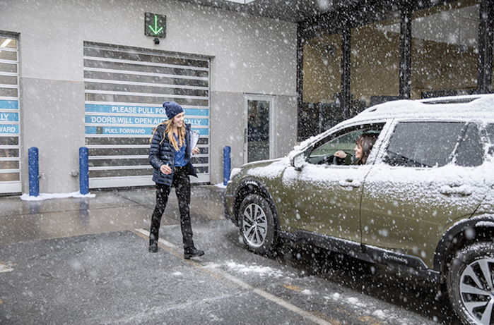 2024 Subaru Outback and customer in the snow