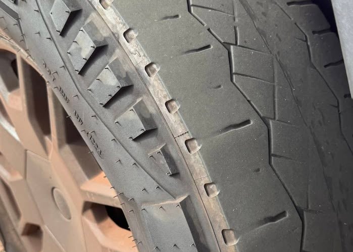 A close up of Leon's Tesla Cybertruck tire shows excessive wear