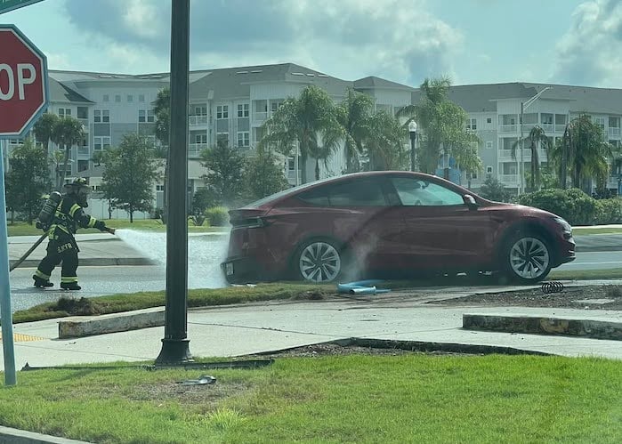 A firefighter puts out a Tesla Model Y car fire 