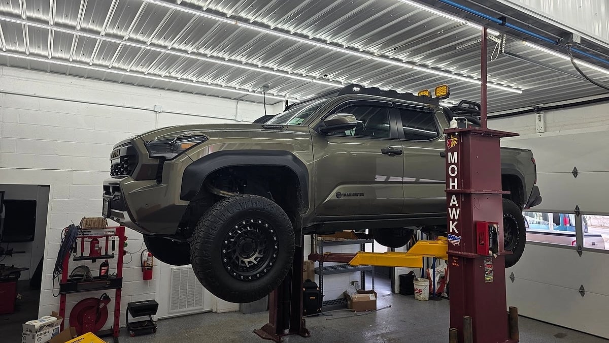 2024 Toyota Tacoma Trailhunter on the dealer's lift for inspection of damaged LED bed rail caps and moisture-related electrical system diagnosis