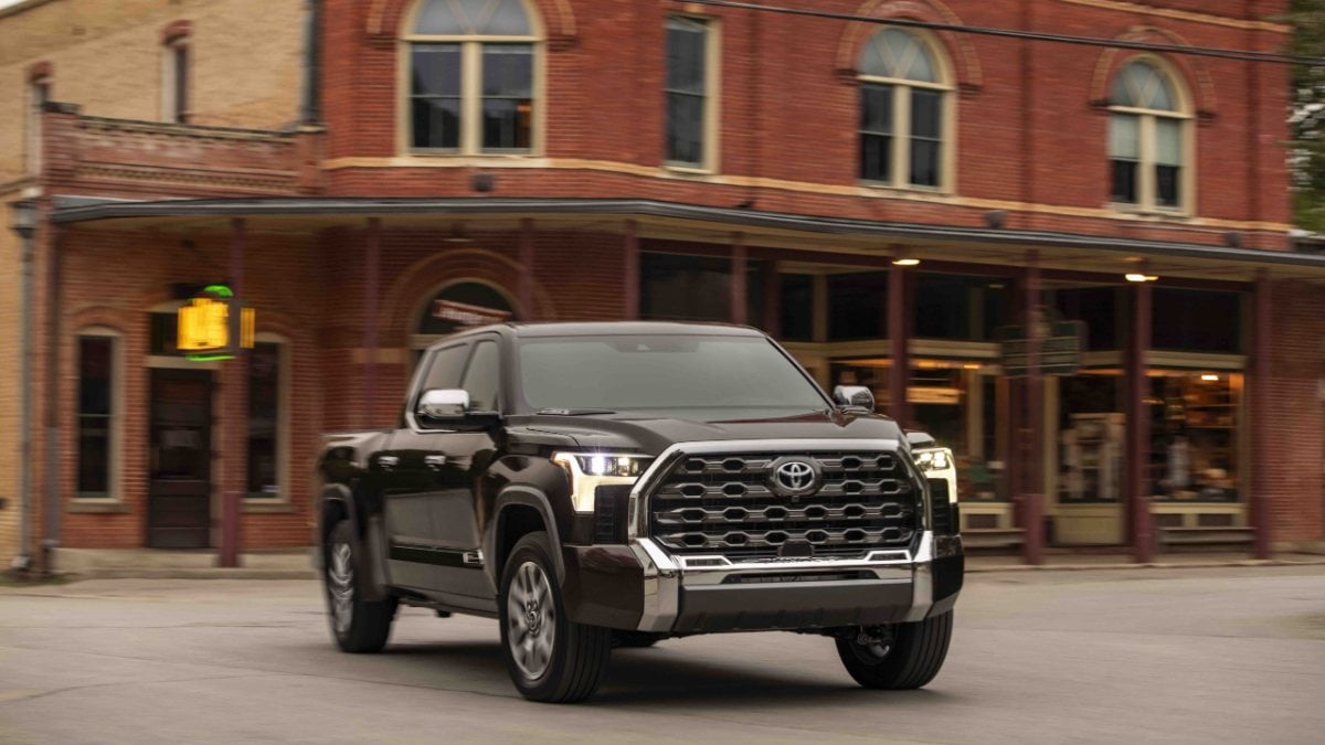 2024 Toyota Tundra 1974 Edition pickup truck shown from front three-quarter angle driving through a historic downtown street.