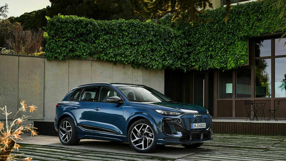 A front three-quarter view of a 2025 Audi Q6 e-tron quattro electric SUV in a vibrant blue color, showcasing the vehicle's distinctive design elements including the grille, headlights, and body lines.