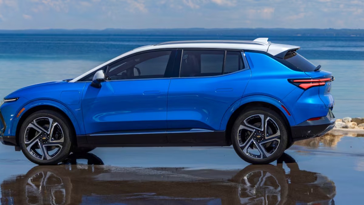 Bright blue Chevrolet Blazer EV SUV parked on reflective surface beside ocean waters