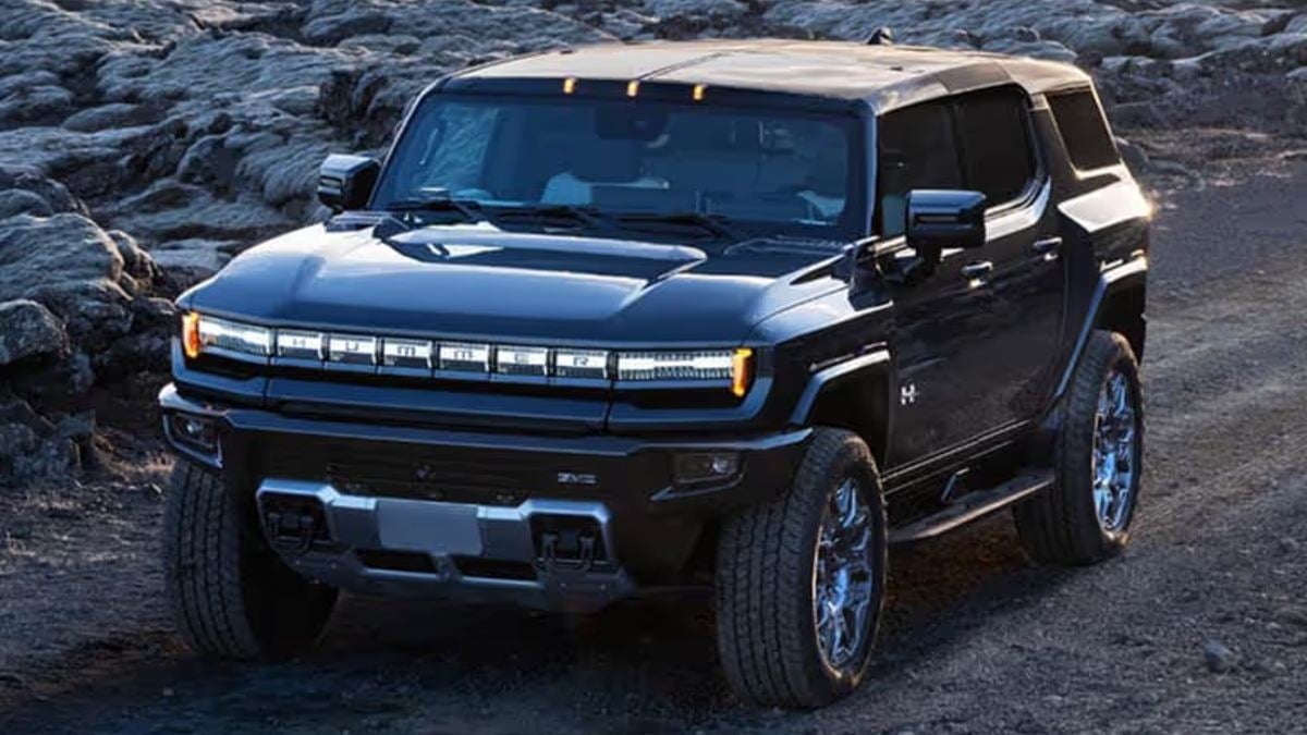 Black GMC Hummer EV SUV parked on rocky terrain with distinctive LED light bar