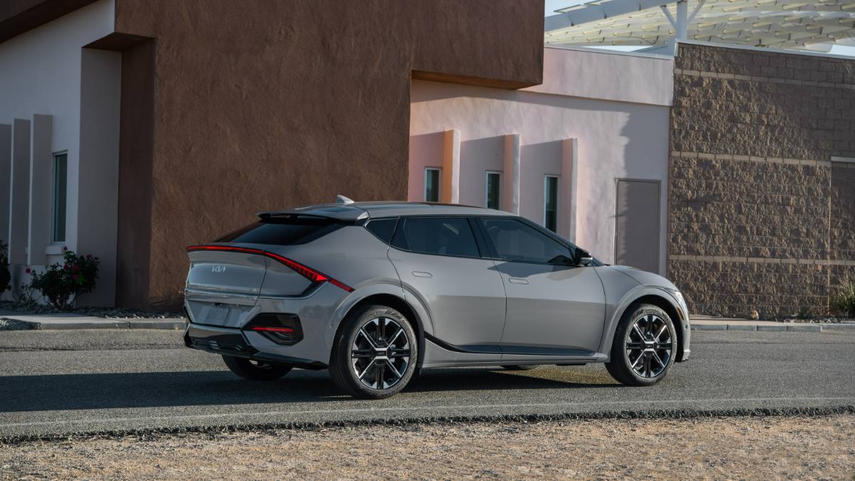 Gray 2025 Kia EV6 rear three-quarter view highlighting full-width LED taillight design and sporty stance.