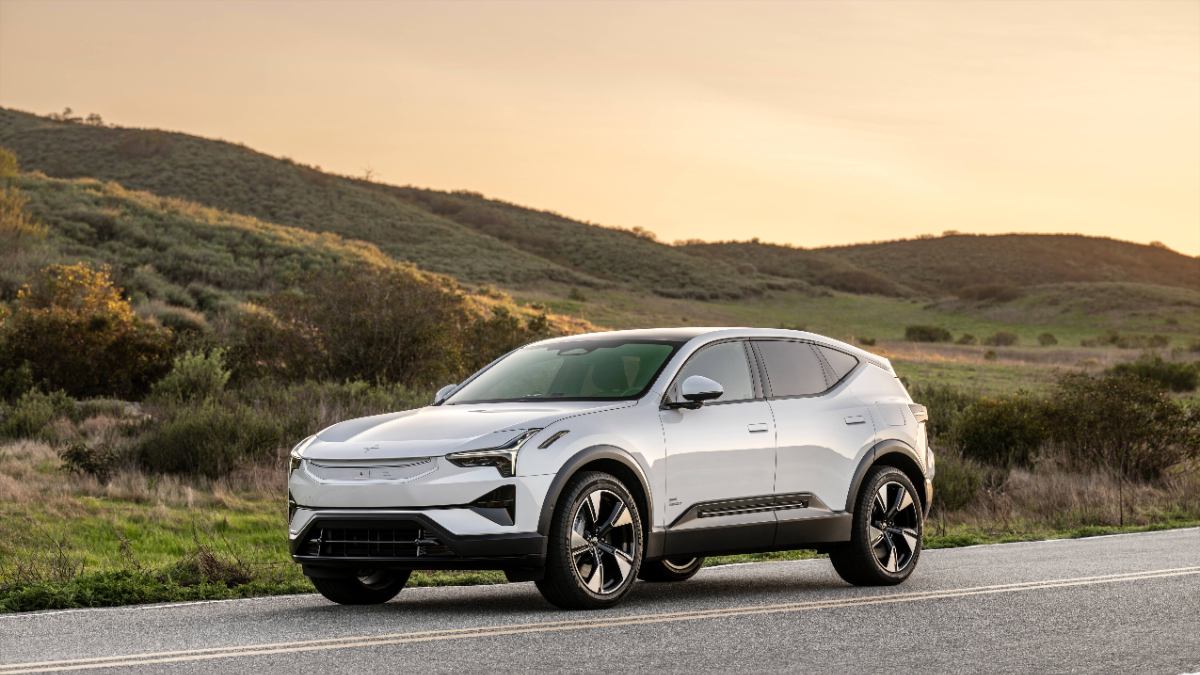 White Polestar 3 SUV parked on mountain road at golden hour, sleek electric crossover with modern design