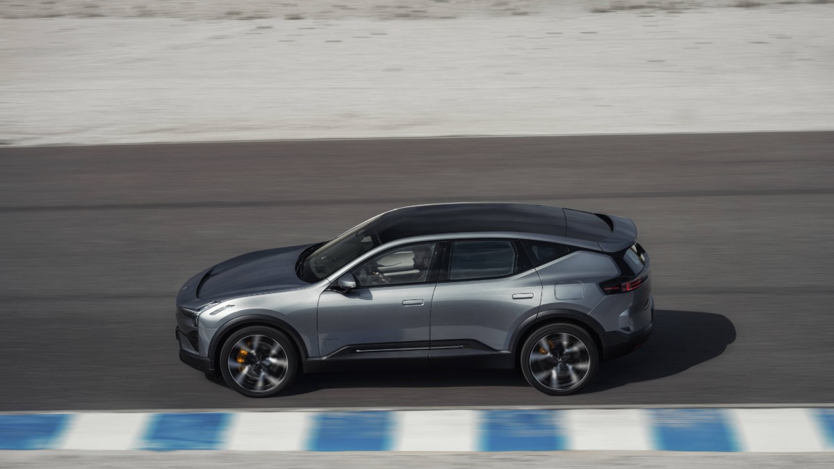 Silver SUV driving on a racetrack with blue and white markings.