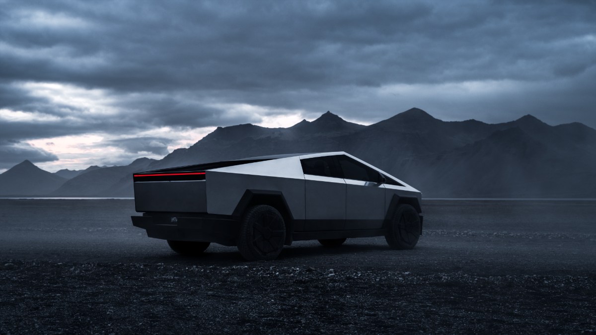 2025 Tesla Cybertruck in metallic gray, parked on dark rocky terrain with dramatic mountain and stormy sky backdrop
