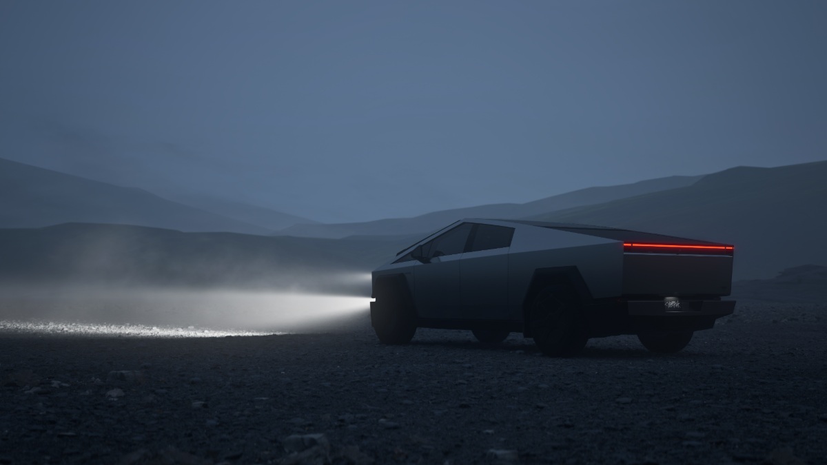 Futuristic truck with headlights on, parked on a misty, rocky landscape at dusk.