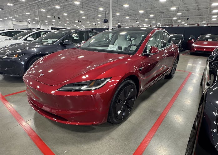 Samuel's Ultra Red 2025 Tesla Model 3 in the showroom