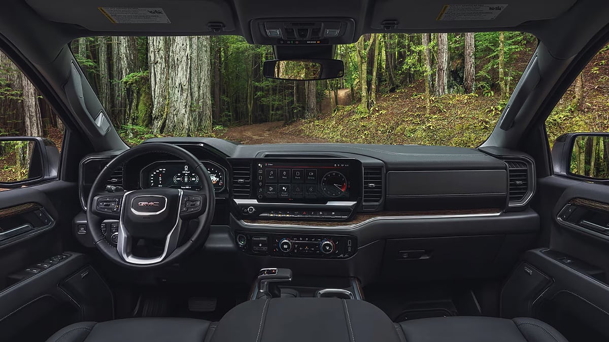 Interior view of a 2025 GMC Sierra 1500 featuring its digital gauge cluster, large infotainment screen, and premium dashboard design.