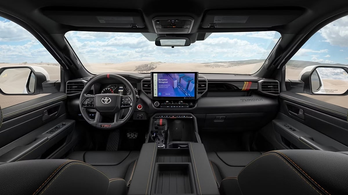 Interior view of a 2025 Toyota Tundra showing the dashboard, steering wheel, center touchscreen, center console, and front seating area.