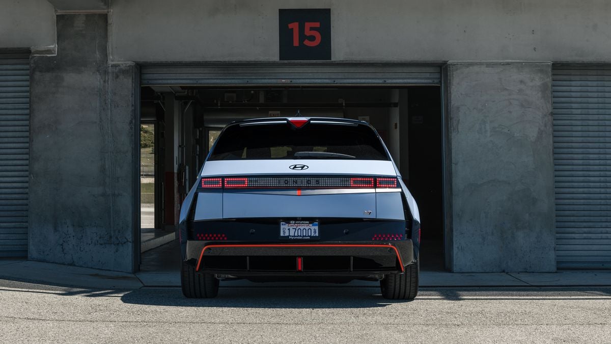 2025 Hyundai IONIQ 5 N in Performance Blue Matte at pit garage entrance, direct rear view showing LED taillights and diffuser