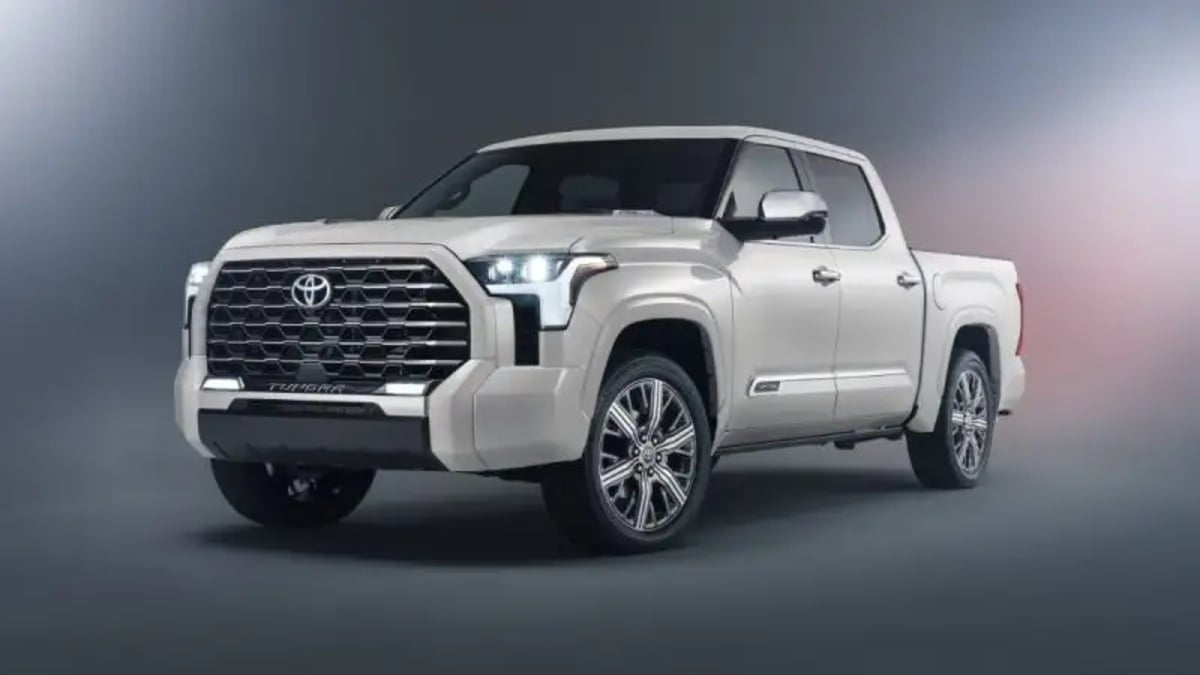 A white 2025 Toyota Tundra Capstone edition shown from the front three-quarter view in a studio setting, highlighting its large chrome grille and modern headlights.