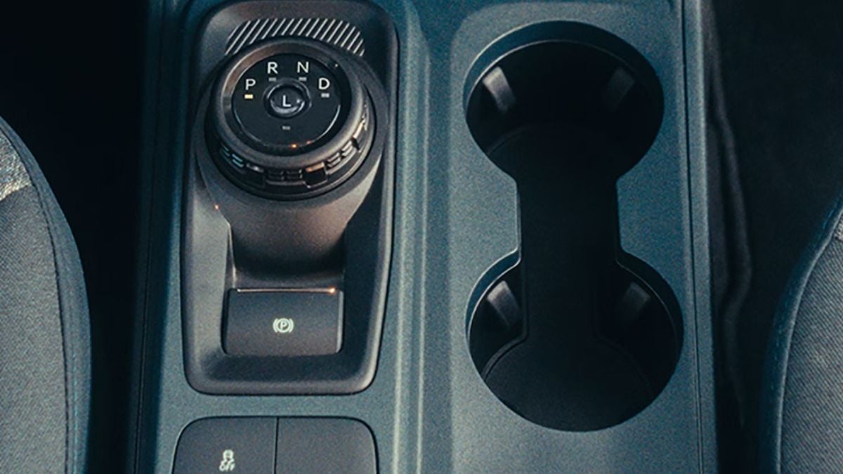Close-up interior view of a 2026 Ford Maverick's automatic transmission gear selector dial showing PRND positions and center console storage compartments.