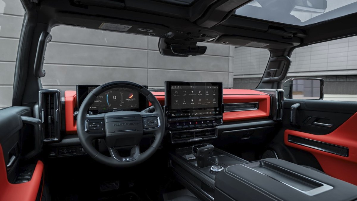 2026 GMC Hummer EV interior showing digital dashboard, large infotainment screen, and red-and-black accents