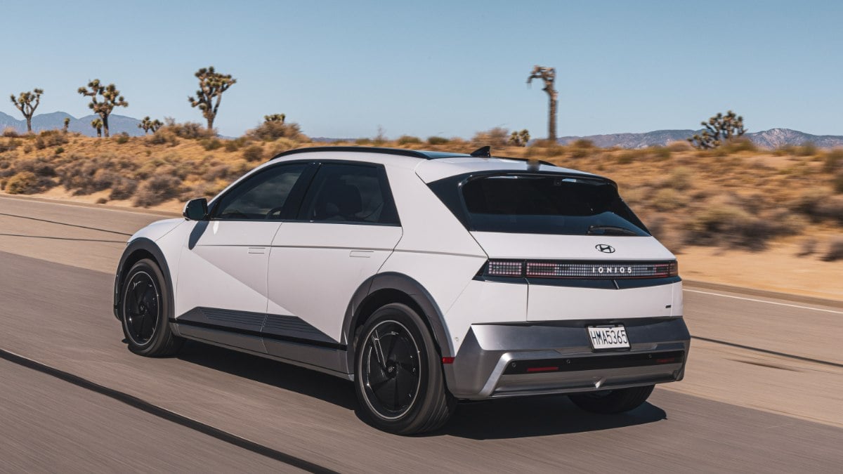 2026 Hyundai Ioniq 5 electric crossover shown from rear three-quarter angle driving on a desert highway.