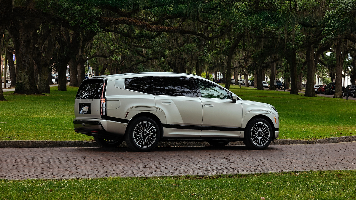 Silver 2026 Hyundai Ioniq 9 electric SUV parked in a park, rear three-quarter view