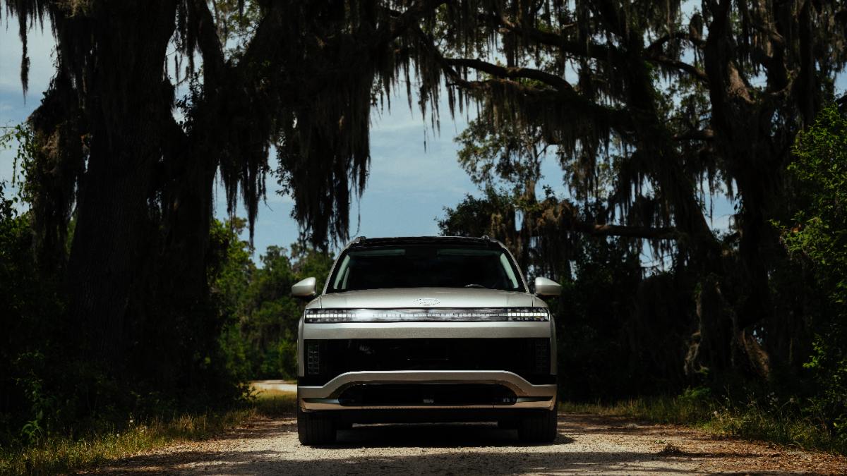 2026 Hyundai Ioniq 9 SUV in silver, front-facing on moss-draped forest path with dramatic lighting