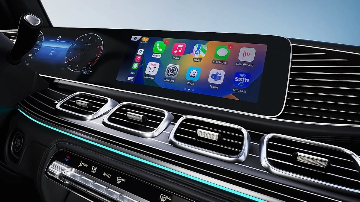 Dashboard of a Mercedes-Benz GLE 350 with a sleek digital display showing apps like Music and Messages. Beneath, elegant air vents and ambient lighting convey sophistication.
