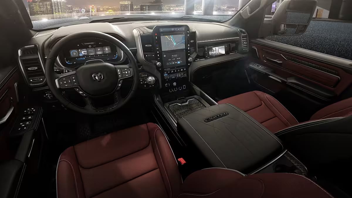 2026 Ram 1500 interior featuring a leather-wrapped steering wheel and red leather seats. Central touchscreen on dashboard, city lights visible outside.