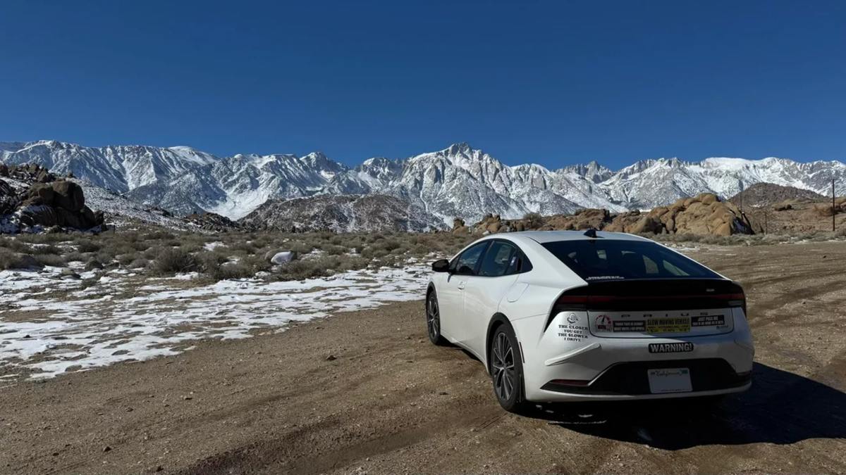 2026 Toyota Prius hybrid rear three-quarter view showing redesigned taillights against snowy mountain backdrop