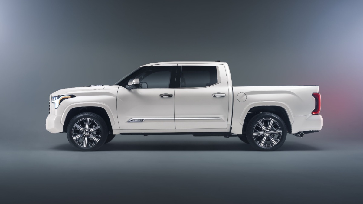 2026 Toyota Tundra full-size pickup truck in white, side profile view showcasing crew cab design, chrome wheels, and modern LED headlights.