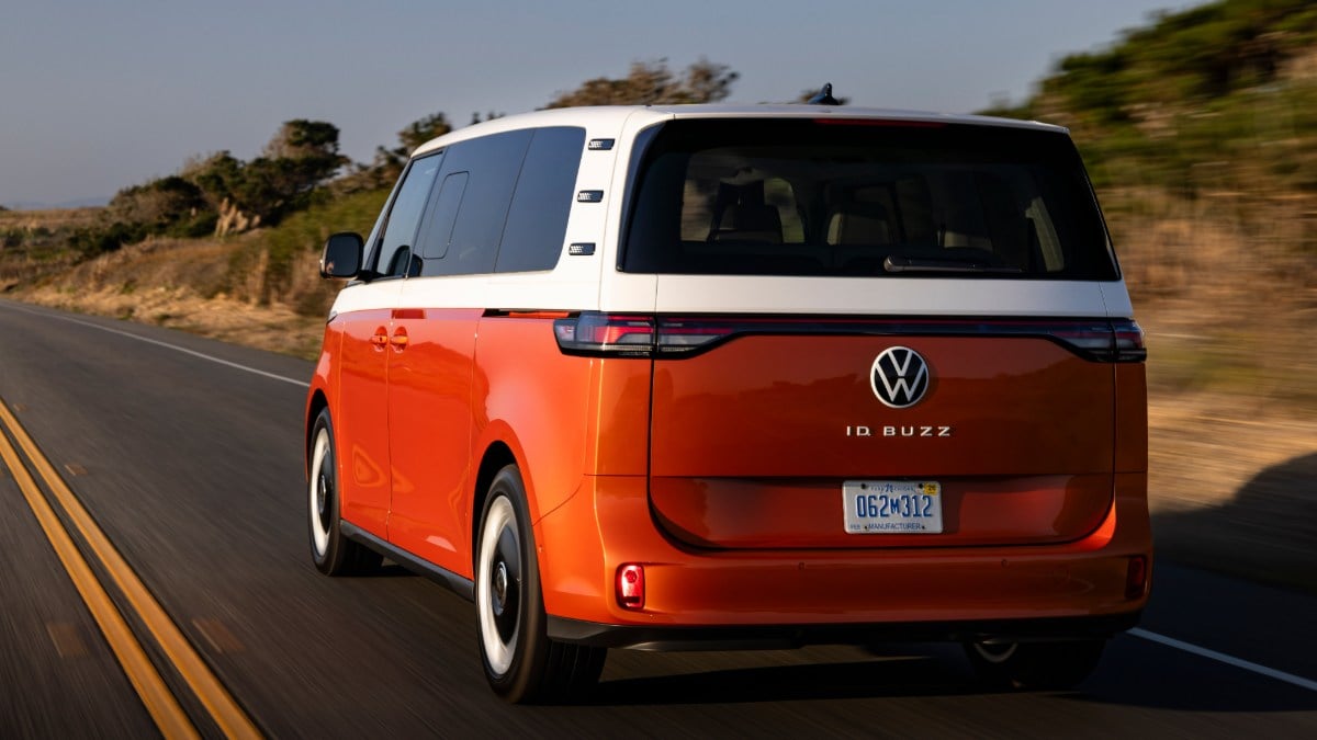 Orange and white Volkswagen ID Buzz electric van driving on coastal highway
