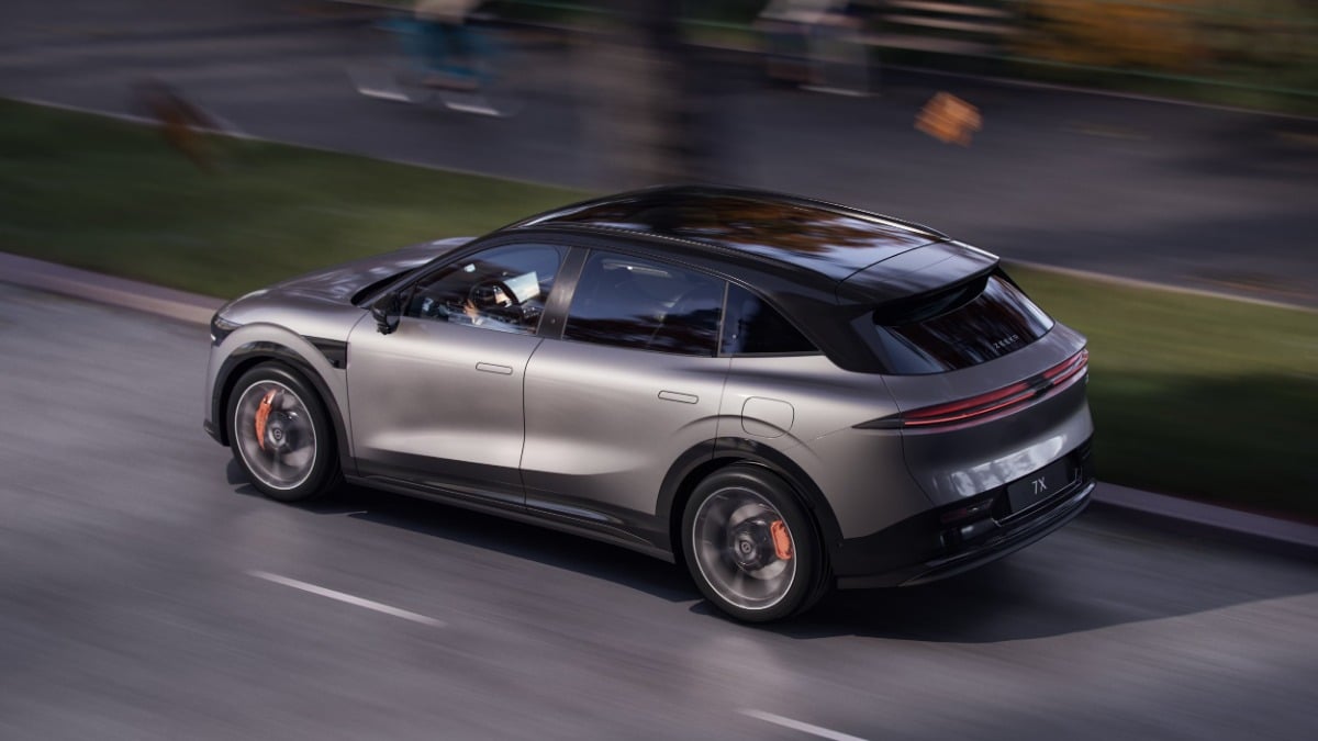 Silver SUV driving on a road, with blurred background indicating motion.