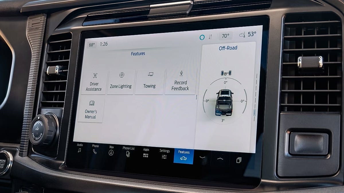 Close-up of the Ford F-150 infotainment system displaying towing, off-road, and driver assistance features.