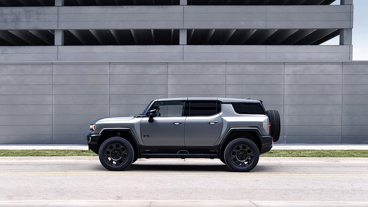 2026 GMC Hummer EV Carbon Fiber Edition SUV shown in side profile against a modern concrete building.