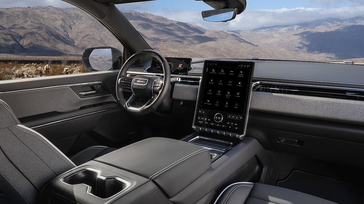 Interior of the 2026 GMC Sierra EV Elevation showing the steering wheel, digital displays and vertical touchscreen.