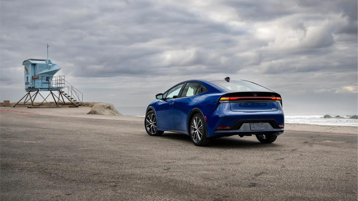 Blue Toyota Prius driving on a suburban road, highlighting its aerodynamic design and hybrid efficiency.
